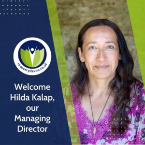 Hilda Kalap smiles alongside the Recovery Devon Daisy logo and the words Welcome Hilda Kalap, our Managing Director